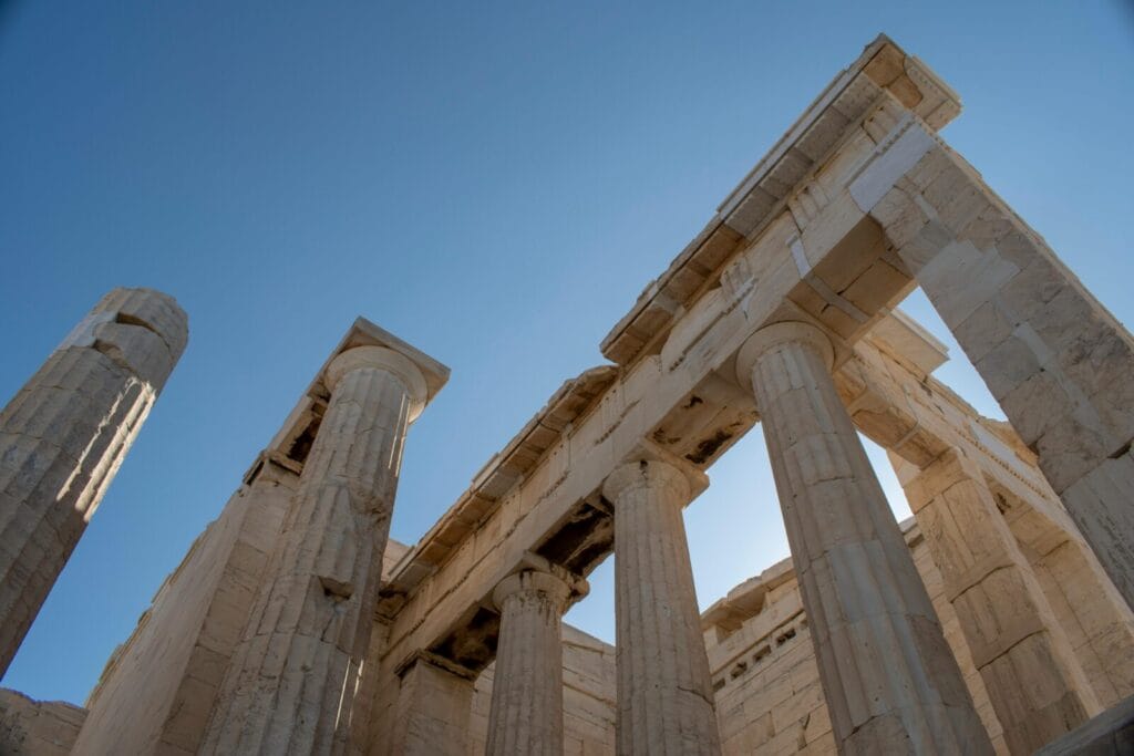 Ancient temple ruins with tall marble columns against a clear blue sky