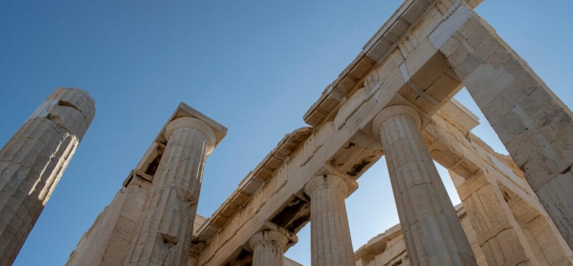 Ancient temple ruins with tall marble columns against a clear blue sky